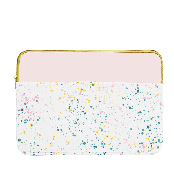 White paint splatter print laptop sleeve with blush pink trim, a gold zipper, and 15 inch size.