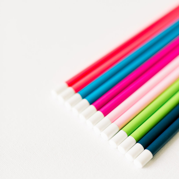Colorful pencil sets in rainbow colors with white erasers on the ends.