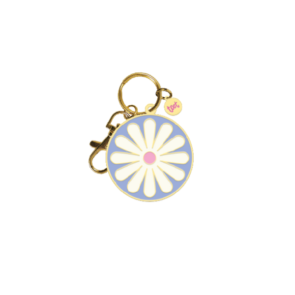 Round blue keychain with white daisy in middle; gold key ring attached