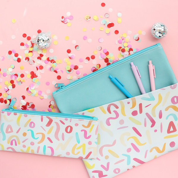 A small pencil pouch and a large pencil pouch with jotter pens, rainbow confetti, and small disco balls.