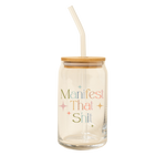A 16 oz can glass with a glass straw. "Manifest That Shit" is printed on the front in multi-color font, with minimalist sparkle-stars surrounding the text.