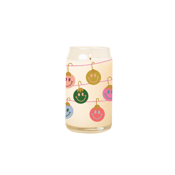 Can glass candle with design of multi-color smiley faced ornaments hanging from garland wrapped around glass.