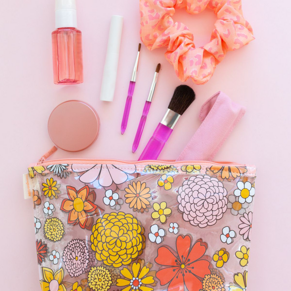 A clear Flower Power Tweedle dee with make up products and wild things scrunchy