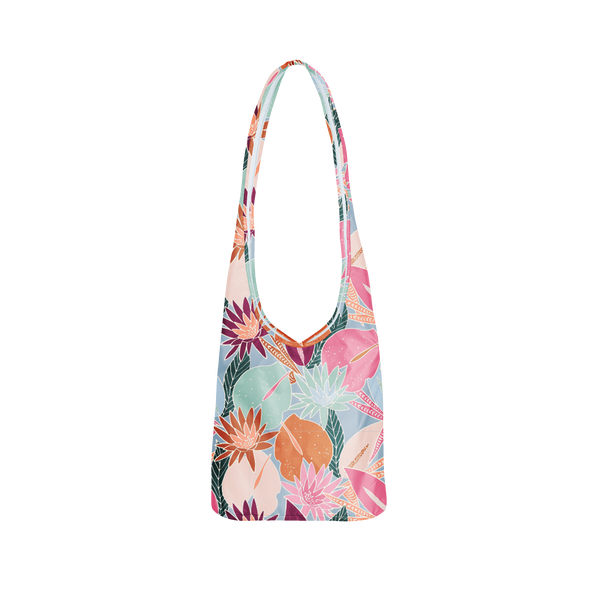 A pale blue colored bagabond crossbody tote with cranberry, orange, teal and pink fall floral leaves