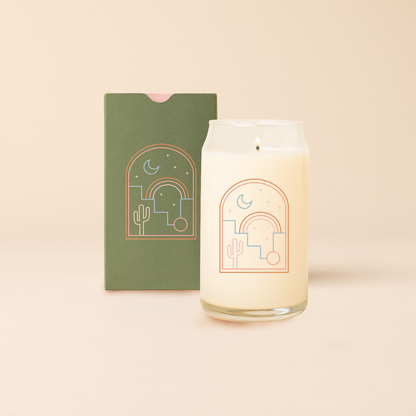 Can Glass Candle with Desert Night view though window. Green box packaging with same design as candle.  