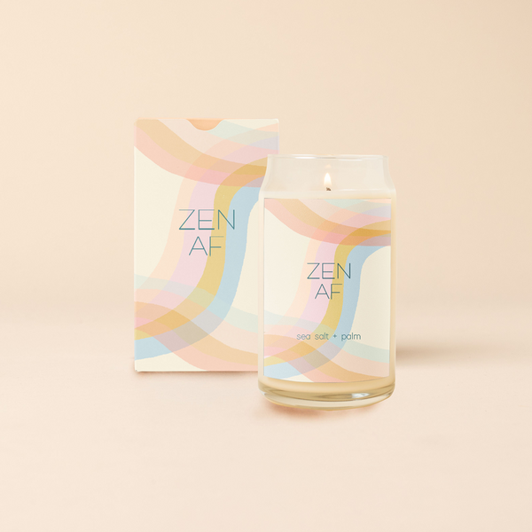 A 16 oz. candle with a decal that has multicolored wavy lines and says "ZEN AF." Scent is sea salt & palm.