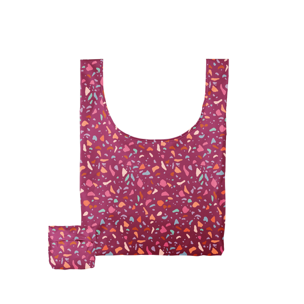 A multicolored, jewel toned Terrazzo speckled tote bag with a magenta background.