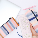 This pencil pouch has multi colored stripes and a navy blue zipper.