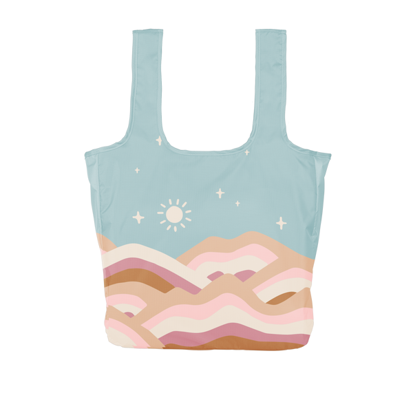 large pastel blue reusable tote bag with pink, brown, and white hill designs on the front and back of the bag.