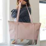 Brunette girl holding a cute travel tote bag in peach mutey fruity vegan leather.