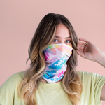 woman wearing rainbow tie dye neck wrap over her nose and mouth.