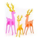 three acrylic reindeer pink, yellow and coral with golden antlers.