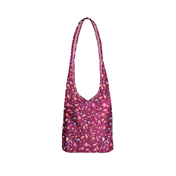 A cranberry colored bagabond crossbody tote with pastel Terrazzo speckles