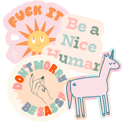 A "Fuck it" sticker, "Be a nice human", "Don't worry be sassy" and a Unicorn sticker. All multicolored.