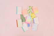a pile of 12 mini notebooks 