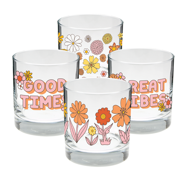 A set of 4 glass cups. One with the phrase "Good Times" printed on with flowers and both ends of the phrase, another with different flowers printed in one line around the cup, one cup with "Great TImes" printed on with flowers at both ends, and one glass with different flower heads printed all over. Colors of flowers and wording on each much are orange, pink, yellow,  and white.