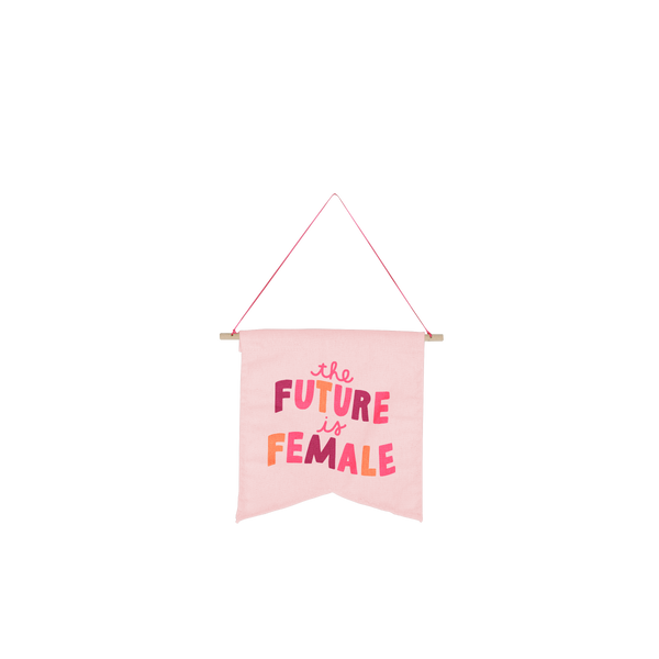 large hanging wall art on pink background with saying the future is female