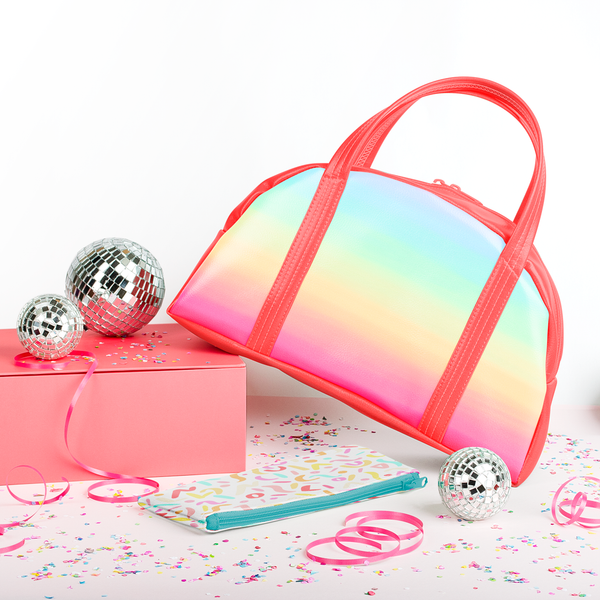 Rainbow handbag surrounded by disco balls and confetti.