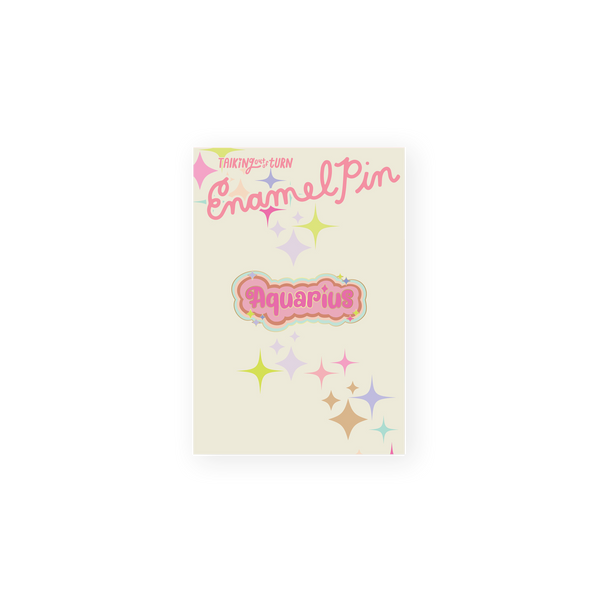 A Aquarius Zodiac Enamel Pin with pink lettering and a lighter pink background. Perimeter lining of pin is in mint, light pink, and tan. Pin also has sparkle stars around "Aquarius."