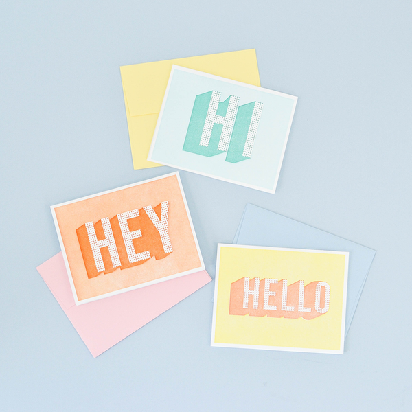 Image of three greeting cards. The top one is light green with a dot pattern that says "HI". The middle one is orange with a dot pattern that says "HELLO". The bottom one is yellow with a dot pattern that says "HELLO".