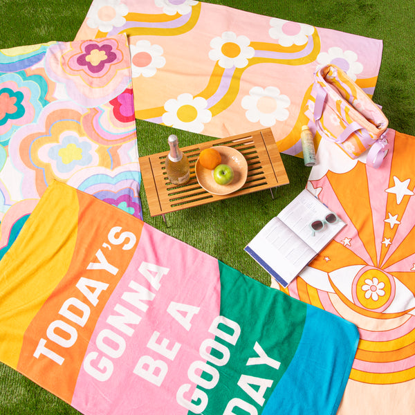 All beach towels on grass with misc items.