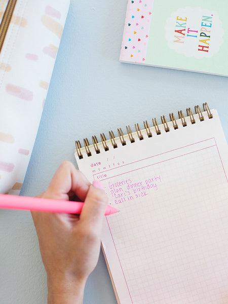 Blush pink jotter pen writing in a taskpad