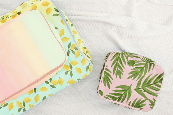 small, medium, and large packing cube set. One with yellow lemons, one pastel gradient, and one with green leaves 