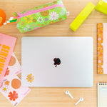desk set up with floral pencil pouch, notebooks, stickers, surrounding computer