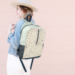 a ripstop backpack with terrazzo print over a girls shoulder
