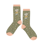 Olive green socks that say "CHILL THE FUCK OUT" with pastel rainbow stars and pale trimmings