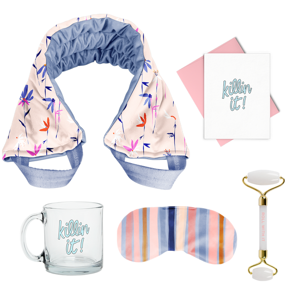 flat image of a collection of self care items including a neck wrap in a small floral print, a clear glass mug that says killing it, a weighted eye mask with blue striped imprint, a greeting card killing it, and a quartz roller with roll with it imprinted in  coral. 