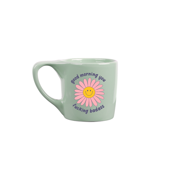 Teal element mug with a pink yellow smiley daisy in the middle of the mug with lowercase "good morning you fucking badass" surrounding it. 
