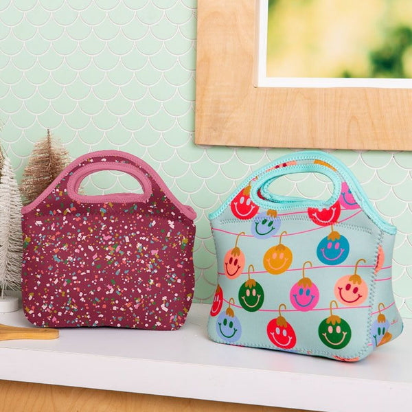 medium soft handbag with handles maroon with multi-color confetti. one medium soft hand bang with handles with blue backgroun and multi-color smiling lightbulbs. 